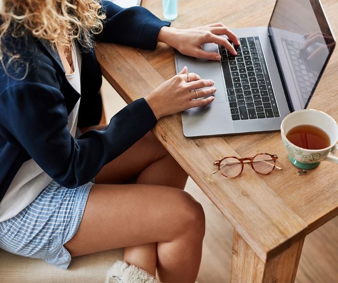 woman sitting at a table working on a laptop computer